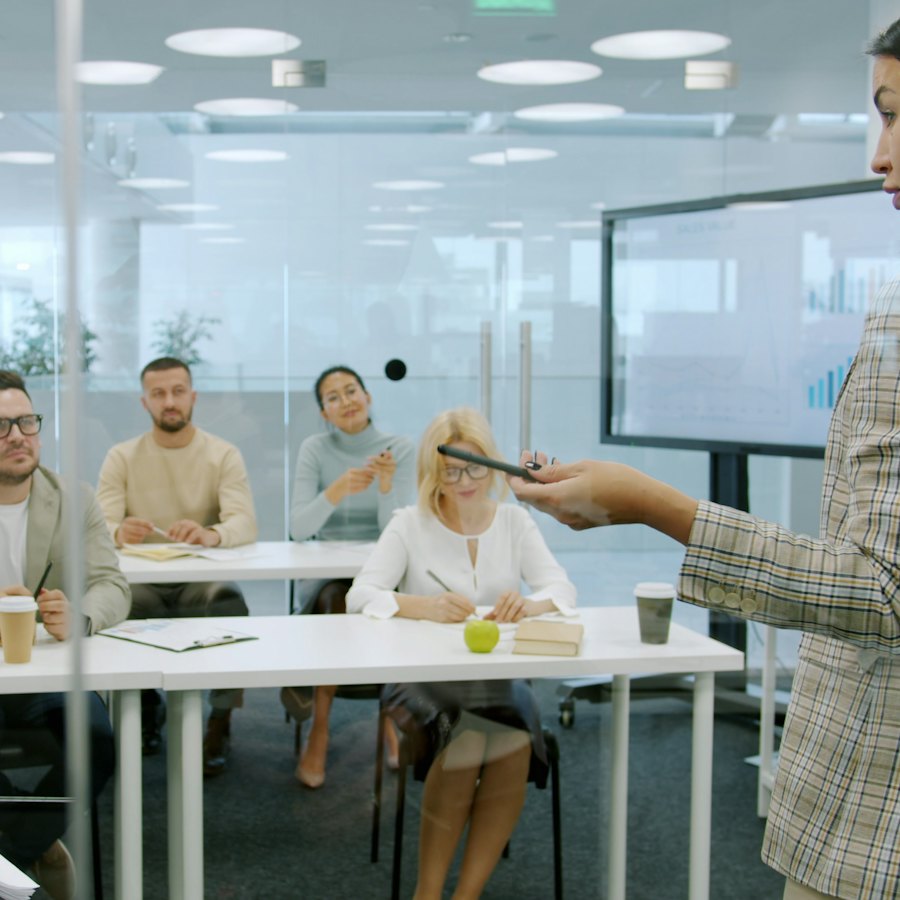 Une formatrice présente à une équipe réunie en salle